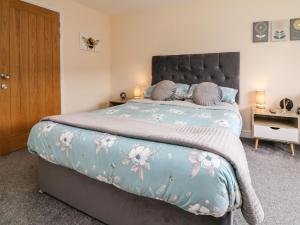 a bedroom with a large bed with a blue comforter at Sunny Views in Ilfracombe