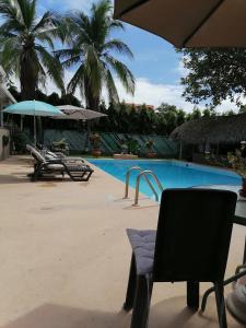 uma piscina com cadeiras e um guarda-sol em B&B EL Litoral em Playa Coronado