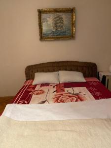 1 dormitorio con 1 cama con una pintura en la pared en Country House Mitrovic, en Babušnica