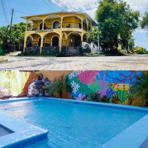 a large yellow house with a swimming pool in front of it at Hostal Casa Moreno in Moyogalpa