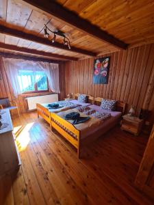 una camera da letto con un grande letto in una camera in legno di Sępia Chata Dom Do Wynajęcia a Świeradów-Zdrój
