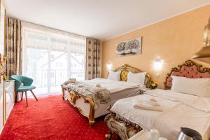 Una habitación de hotel con dos camas y una ventana. en Artemis Villa, en Poiana Brasov