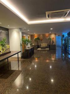 een lobby met een bank en tafels en planten bij Conforto, luxo e melhor localização da cidade in Manaus