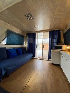 a living room with a blue couch and a kitchen at Yate Gijon , experiencia unica J in Gijón