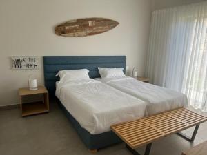 una camera da letto con un letto grande e una panca di legno di SANTOSHA a Tamarin