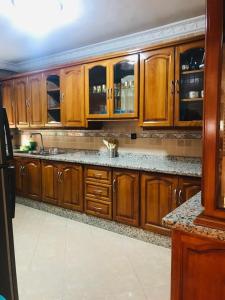 a kitchen with wooden cabinets and a sink at Apartamento hay amal 12 in Salé