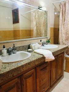 La salle de bains est pourvue de 2 lavabos et d'un grand miroir. dans l'établissement Apartamento hay amal 12, à Sale