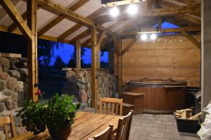 un patio al aire libre con una mesa de madera y una bañera en Zagroda nad Hańczą, en Błaskowizna