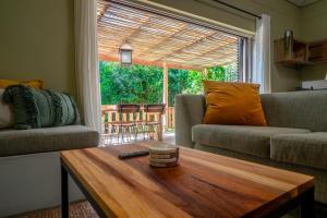 a living room with a couch and a coffee table at Treebia Self-catering - Loadshedding Free in Plettenberg Bay