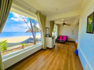 a room with a large window with a view of the beach at Casa Beach Resort in Phan Thiet