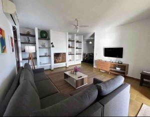 ein Wohnzimmer mit einem Sofa und einem TV in der Unterkunft Vilas RCM - Casa das redes in Barra Velha