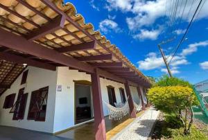 ein Haus mit einer Terrasse mit einer Hängematte im Freien in der Unterkunft Vilas RCM - Casa das redes in Barra Velha