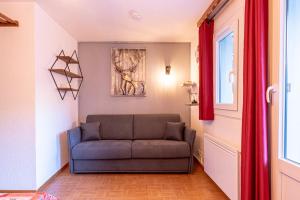 ein Wohnzimmer mit einem Sofa in einem Zimmer in der Unterkunft Les gentianes 311 in Les Menuires