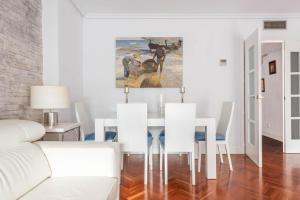 una sala de estar blanca con una mesa y una pintura en Bonita habitación con balcón, en Villaviciosa de Odón