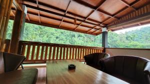 a table and chairs in a room with a large window at Sam's Bungalows in Bukit Lawang