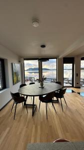 a dining room with a table and chairs with a view at Nordic Waterside Escape in Ulvsvåg