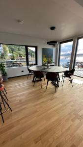 a dining room with a table and chairs and windows at Nordic Waterside Escape in Ulvsvåg