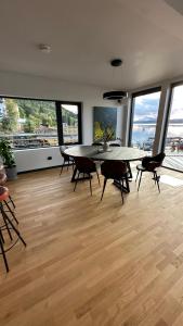a dining room with a table and chairs and windows at Nordic Waterside Escape in Ulvsvåg +10 photos