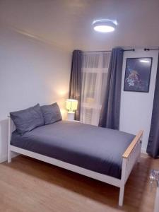 una camera da letto con un letto con lenzuola blu e una finestra di Big spacious 4 Bed House Romford London a Harold Wood