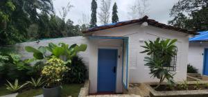 una pequeña casa con una puerta azul en Wild Orchid 5BHK Villa & Eco Cottages in Sancoale Valley en Sancoale
