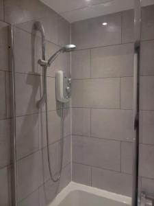 um chuveiro na casa de banho com um telefone na parede em Big spacious 4 Bed House Romford London em Harold Wood