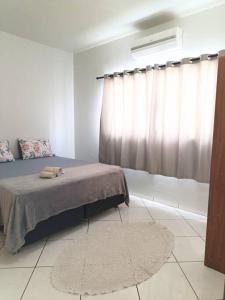 een slaapkamer met een bed, een raam en een tapijt bij Lindo Apto105 em primavera do Leste in Primavera do Leste