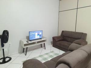 een woonkamer met een bank en een tv op een tafel bij Lindo Apto105 em primavera do Leste in Primavera do Leste