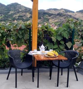 een tafel met twee stoelen en een bord bananen erop bij Studio em Machico in Machico