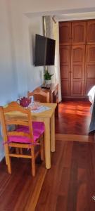 a dining room with a table and a television at Studio em Machico in Machico
