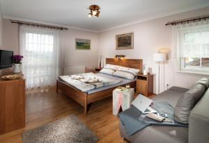 - une chambre avec un grand lit et un canapé dans l'établissement Pension Luky, à Špindlerův Mlýn