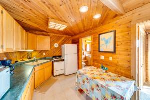 a kitchen with a refrigerator and a table in it at Lakefront Wisconsin Escape with Boat Dock and Kayaks! in Oconomowoc