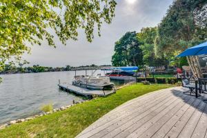 a dock with a boat on the water at Lakefront Wisconsin Escape with Boat Dock and Kayaks! in Oconomowoc