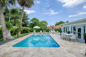 a patio with a swimming pool and a table and chairs at Avocado Hideaway in Boynton Beach