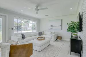 a white living room with a couch and a table at Avocado Hideaway in Boynton Beach