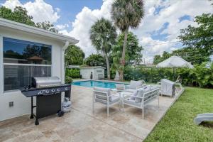 a backyard with a grill and chairs and a pool at Avocado Hideaway in Boynton Beach