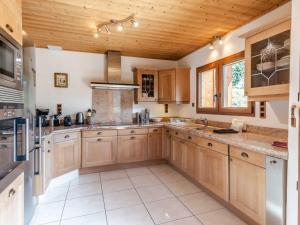 eine große Küche mit Holzschränken und einer Holzdecke in der Unterkunft Chalet rénové 4* avec cheminée et animaux admis - FR-1-754-32 in Morzine