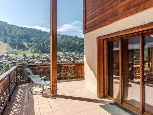 einen Balkon mit einem Stuhl und Stadtblick in der Unterkunft Chalet rénové 4* avec cheminée et animaux admis - FR-1-754-32 in Morzine + 6 Fotos