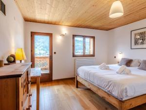 ein Schlafzimmer mit großem Bett und Holzdecke in der Unterkunft Chalet rénové 4* avec cheminée et animaux admis - FR-1-754-32 in Morzine