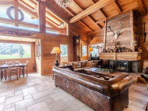 a living room with a leather couch and a fireplace at Chalet Morzine, 7 pièces, 14 personnes - FR-1-754-8 in Morzine