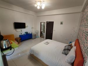 - une chambre avec un lit et une télévision dans l'établissement Adore Yilan, à Luodong