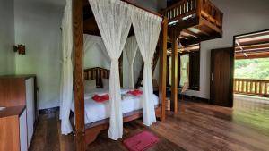 a bedroom with a canopy bed with mosquito nets at Sam's Bungalows in Bukit Lawang
