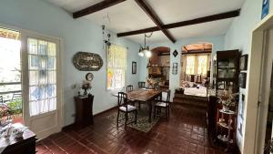 a living room with a table and a dining room at Refúgio Pasárgada Guest House in Mairiporã
