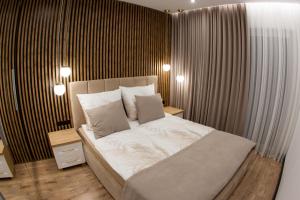 - une chambre dotée d'un grand lit avec des draps et des oreillers blancs dans l'établissement Apartament POSEJDON Gliwice, à Gliwice
