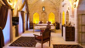 a bedroom with a bed and a tv in a room at AĞA KONAĞI HOTEL in Mardin