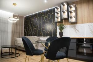 een woonkamer met een bank en een tafel en stoelen bij Apartament POSEJDON Gliwice in Gliwice