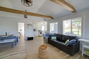 uma sala de estar com um sofá preto e uma cozinha em Stylish Grass Lake Retreat - Steps to Park! em Grass Lake