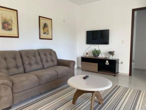 uma sala de estar com um sofá e uma mesa em RCM Vilas - Casa confortável 1 em Joinville