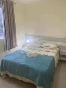 una camera da letto con un letto e asciugamani di RCM Vilas - Loft mobiliado a Joinville