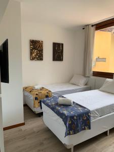 a room with two beds and a table in it at Apartamento de alto padrão no centro de Barra Grande in Barra Grande