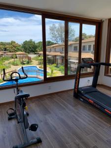 a gym with a view of a swimming pool and two tread machines at Apartamento de alto padrão no centro de Barra Grande in Barra Grande